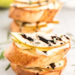 Pear and brie crostini with balsamic vinegar on a table