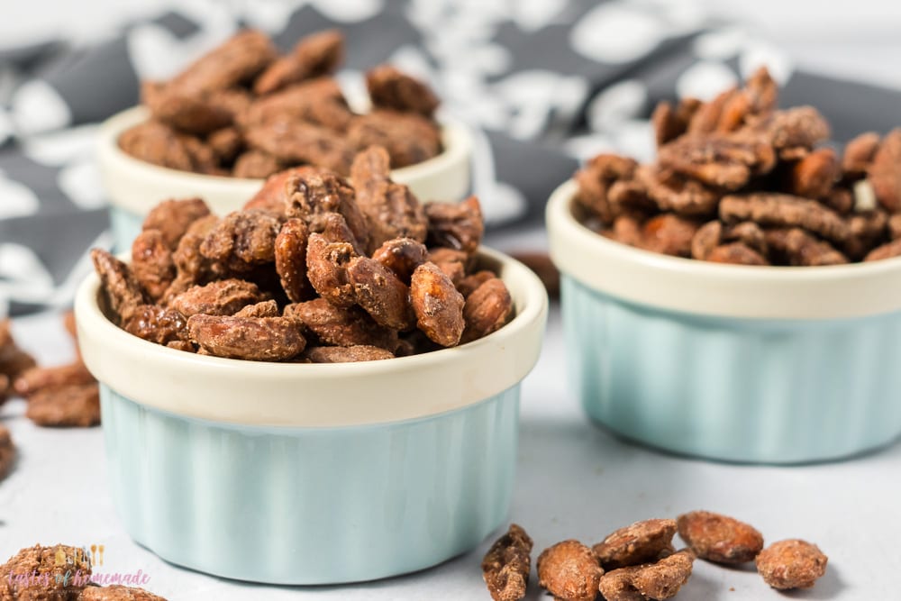 Candied nuts in three bowls on a table.