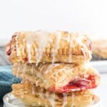 3 cherry turnovers stacked on a small white plate
