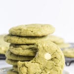 Stack of cookies on a white plate with a bite out of one cookie