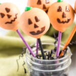 Close up of jack-o-lantern decorated cake pop in decorative jar.