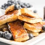 Stack of French toast drenched in syrup.
