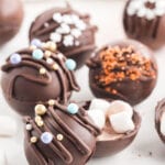 Hot chocolate bomb split open with sprinkles on top and marshmallows inside.