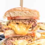 Stuffed cheese burger cut in half with a wooden skewer holding it together.