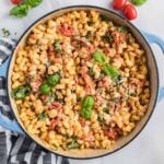 Pasta with tomatoes, feta and basil in a blue casserole dish.