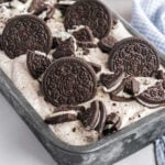 Oreo ice cream in a metal loaf pan topped with whole and crushed Oreos.