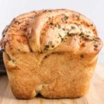 Front view of twisted cheese bread showing puffed crown and melted cheese and herbs.