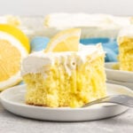 Lemon cake with white frosting on a small plate.