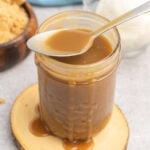 Butterscotch sauce in a small mason jar with a spoon.