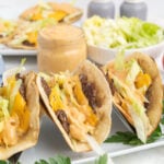Burger tacos with cheese, lettuce and burger sauce on a plate.