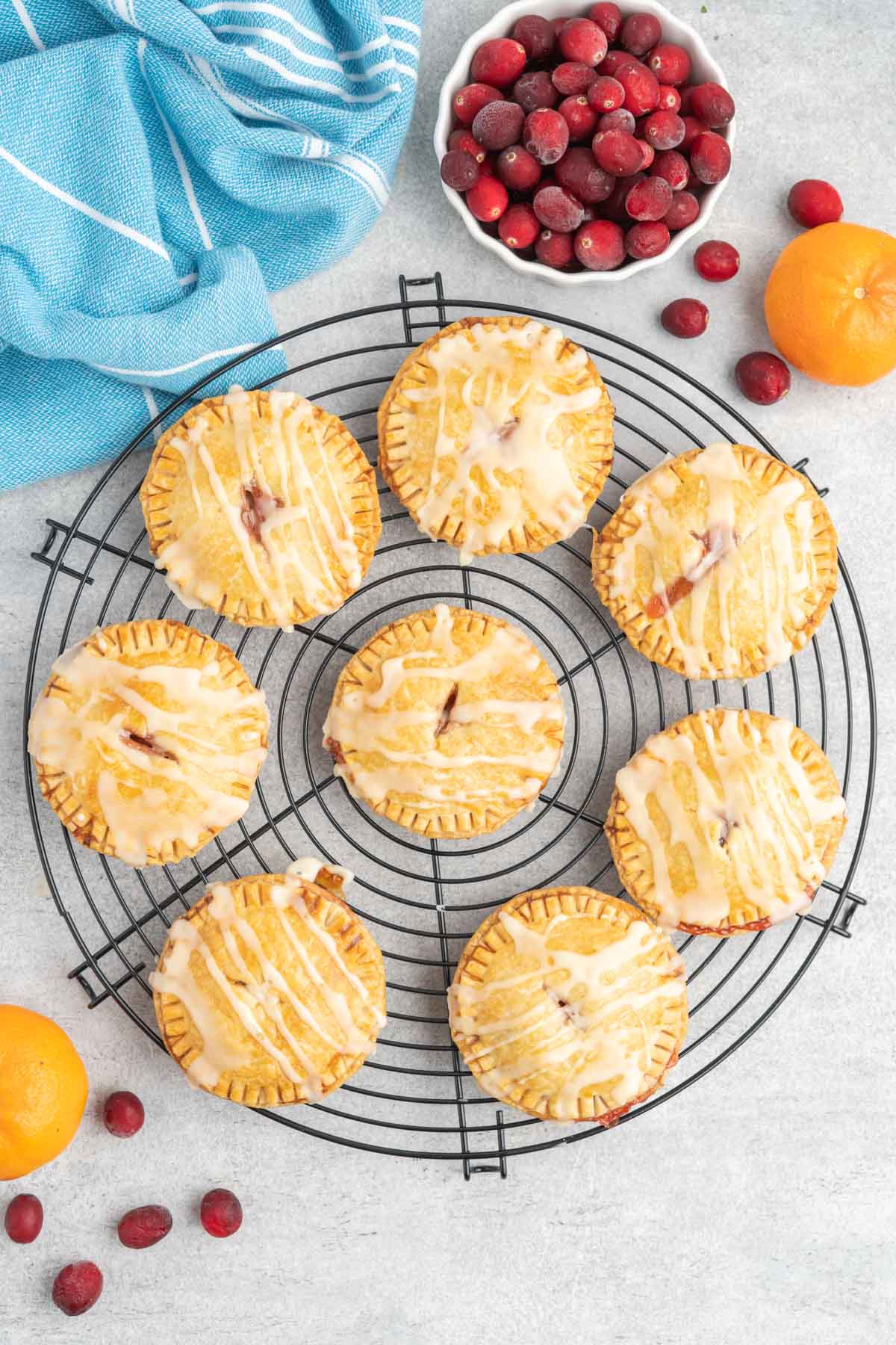 Round handpies with icing drizzle on a round cooling rack. 