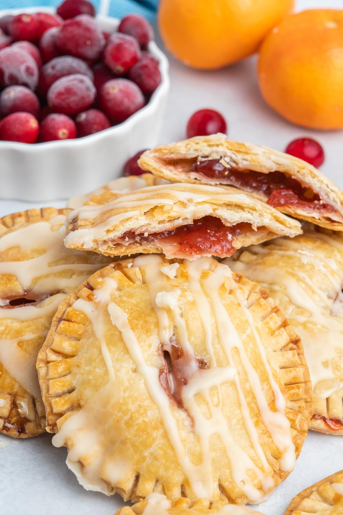 A pile of hand pies with one broken open showing cranberry sauce filling.