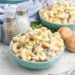 A small bowl of white cheddar mac and cheese with mushrooms.