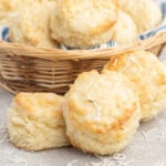 Baking powder biscuits with glaze and flaked coconut in a basket.