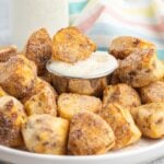 Cinnamon sugar bites on a plate being dipped in cream cheese icing.