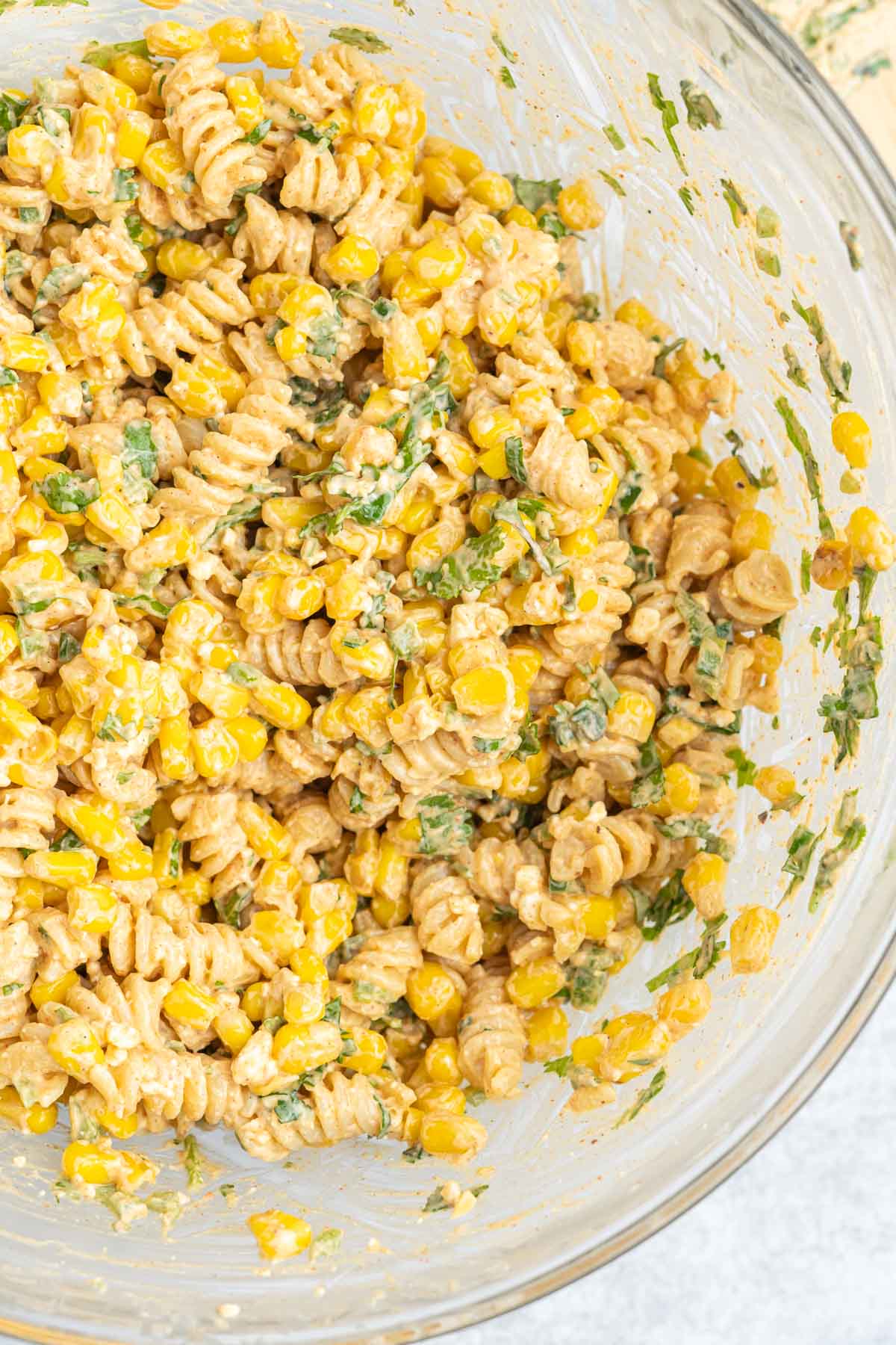 Prepared pasta salad in a large mixing bowl. 