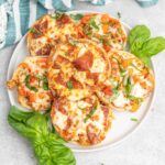 Pepperoni english muffin pizzas on a plate.