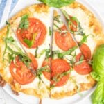 Tomato basil pizza with mozzarella cheese on flatbread.