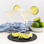 Two lime martinis garnished with lime slices.