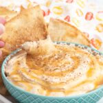 Pumpkin dip with caramel drizzle with a cinnamon pita chip.