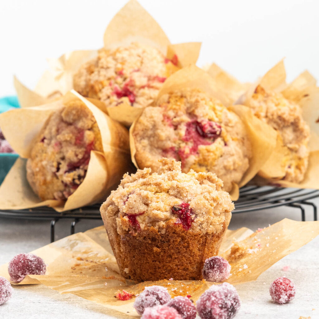 Cranberry muffin with streusel topping on a muffin liner.