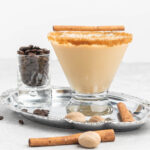 Eggnog martini in a stemless glass rimmed with brown sugar.