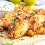 Cooked boneless chicken things on a cutting board with ranch dip.