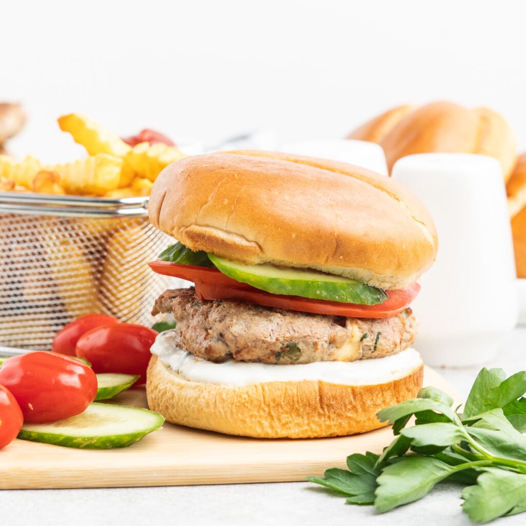 Turkey burger with cucumber and tomato on a brioche bun.