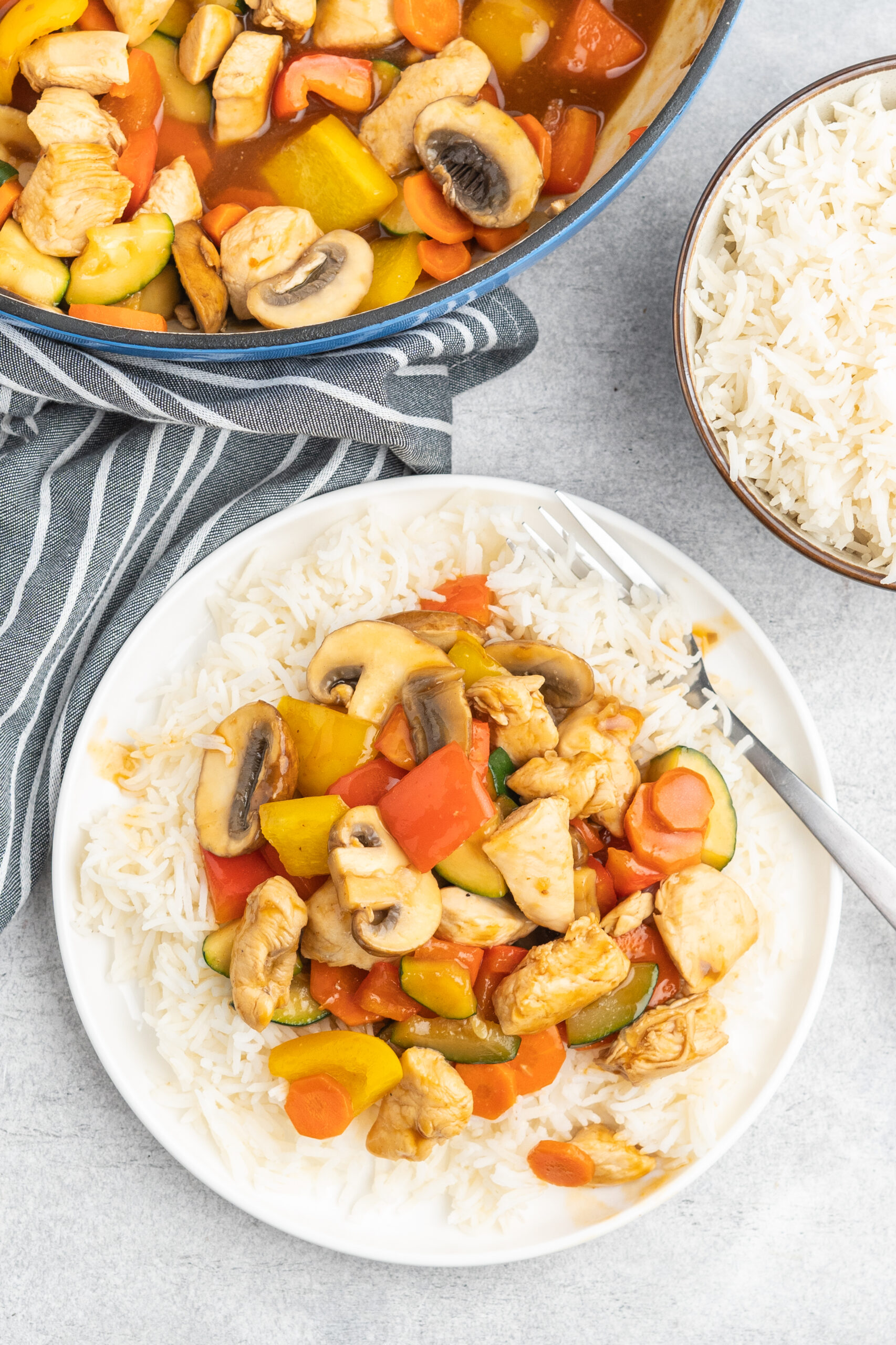 A serving of chicken stir fry on rice. 