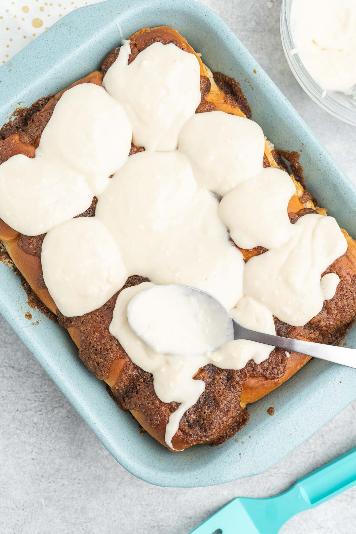 Cinnamon rolls in a baking dish with cream cheese frosting.