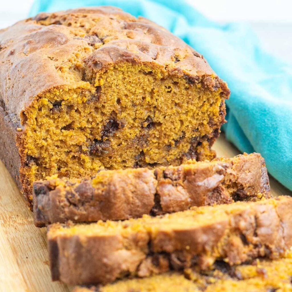 Sliced pumpkin chocolate chip loaf on a cutting board.