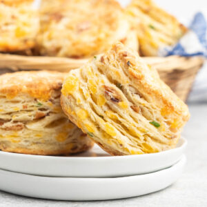 Two bacon and cheese scones on a small plate.