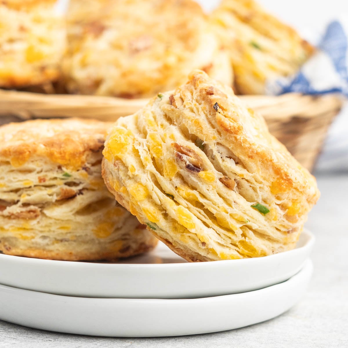 Two bacon and cheese scones on a small plate.