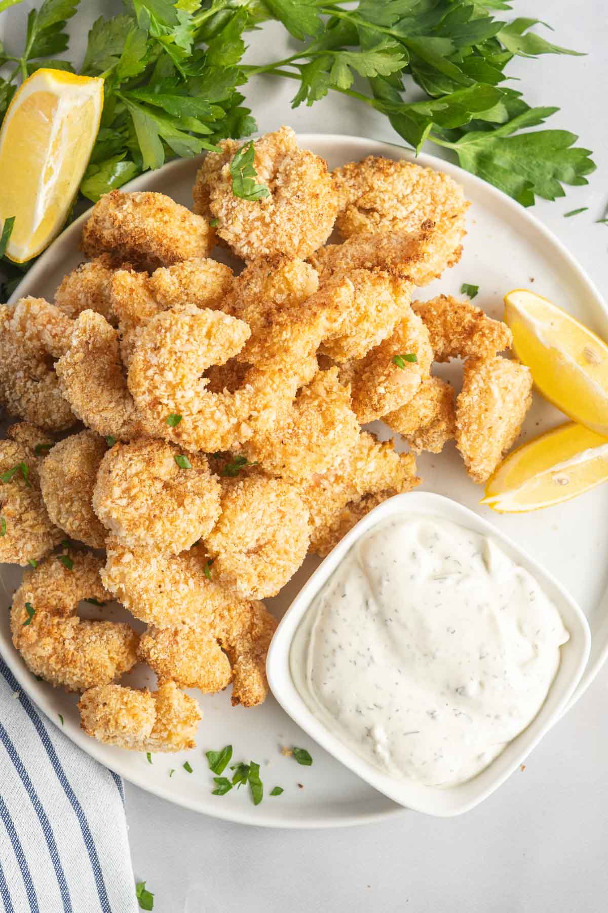 Platter of crispy shimp with dip and lemon wedges. 